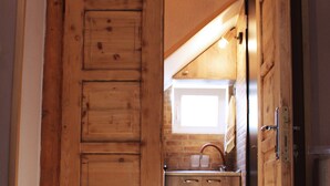 Interior de madera con zona de cocina, que incluye un lavamanos y armarios.