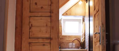 A wooden interior with a kitchen area, including a sink and cabinets.