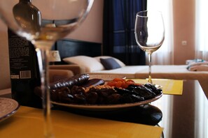 Een eettafel met een bord eten, een fles en een wijnglas.