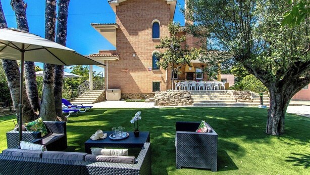 Un edificio de ladrillo con un patio amoblado y una mesa de comedor.