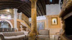 Un interior imponente con techo alto, una escalera, una columna grande y una chimenea.
