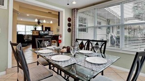 A dining area with a glass table set for four, surrounded by chairs.