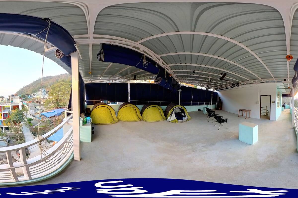 A spacious indoor area with a curved ceiling and multiple yellow tents.