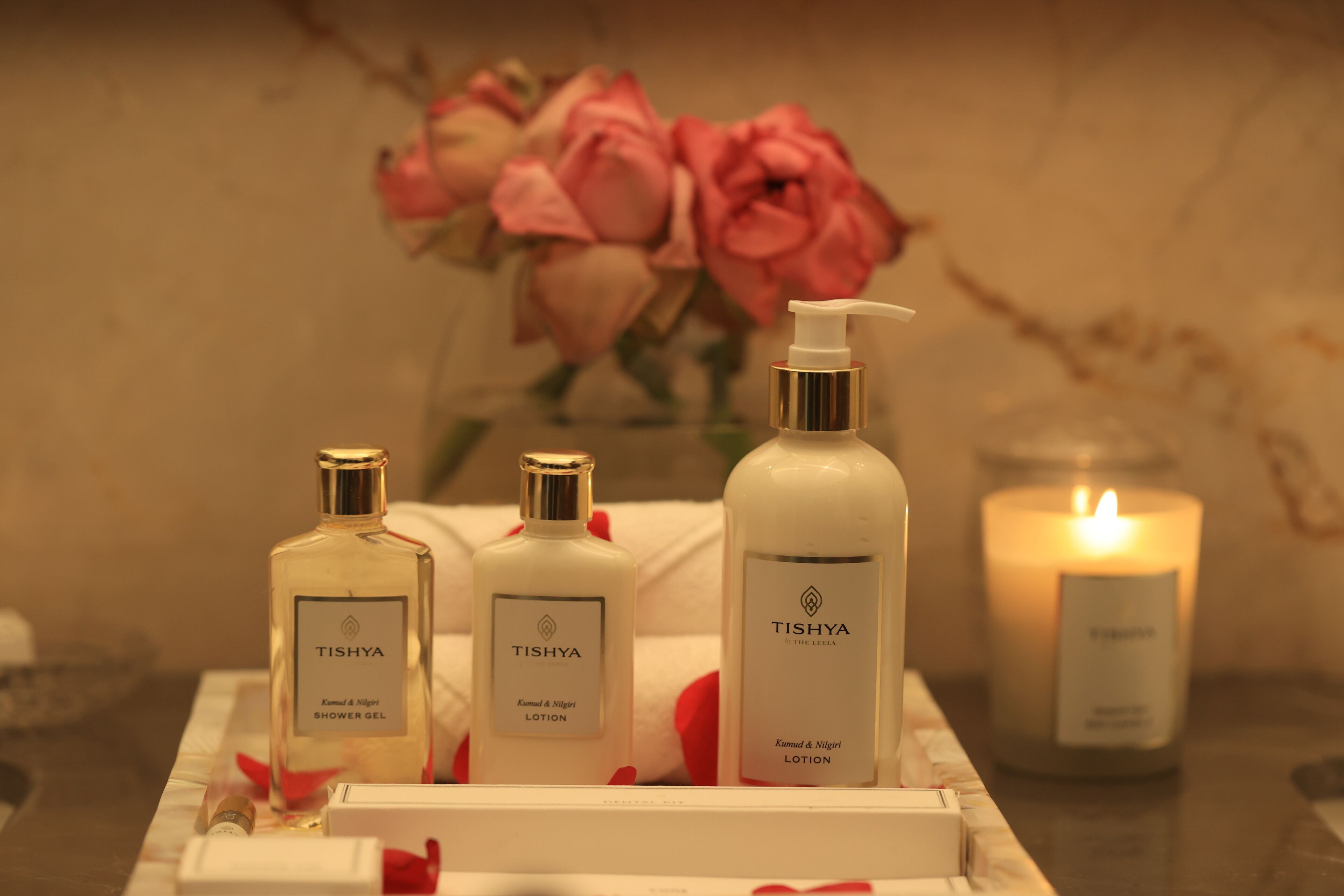 A bathroom vanity with three Tishya products: shower gel, lotion, and candle.