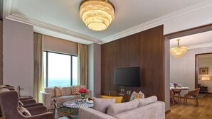 Una sala de estar moderna con un sofá, sillones, una mesa de centro y un televisor.