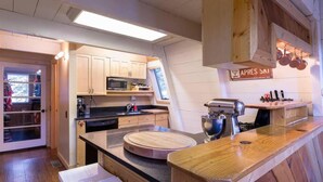 A kitchen with wooden cabinets, a microwave, a sink, and a wooden countertop. - Zephyr by AvantStay | Stylish Frame w/ Access To Tahoe Donner (Truckee)