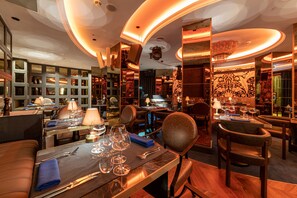A restaurant with multiple dining tables, chairs, and a bar area.