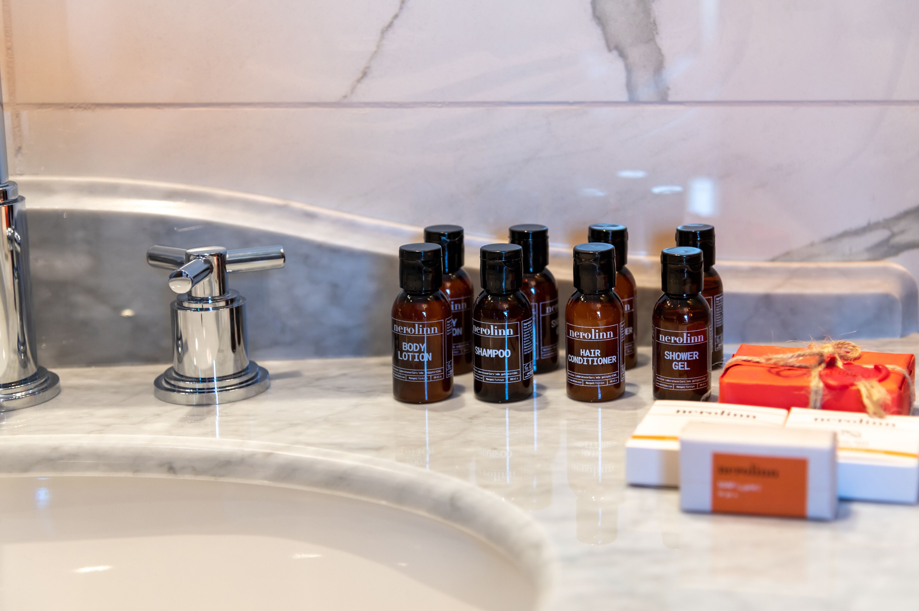 Uma pia de banheiro com várias embalagens de produtos para cabelo e uma caixa de presente.