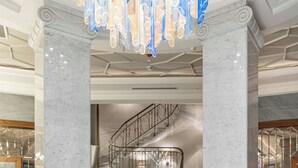 A lobby with marble columns, a reception desk, and a modern chandelier. - Orientbank Hotel Istanbul, Autograph Collection (Istanbul)