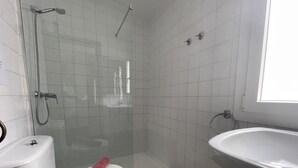 Une salle de bain avec des toilettes, une douche et un lavabo.