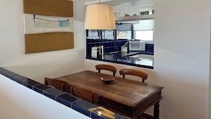 A dining area with a wooden table, chairs, and a hanging light fixture. - In a very quiet area within the town (Fornells)