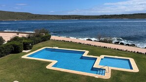 Una piscina con vistas al mar y las colinas.