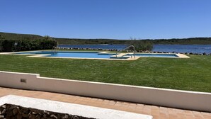 Una piscina con vista al mar y a las colinas.