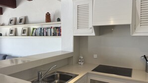 A modern kitchen with a built-in sink, stainless steel appliances, and white cabinetry. - Apartment with sea views and pool in Fornells (Fornells)