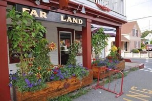 Welcome to FAR LAND, a traditional building with a charming entrance and lush greenery.