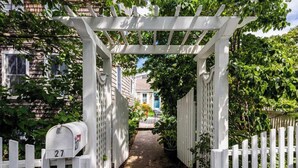 A white wooden gate with a mailbox marked '27' leading to a pathway. - 5 Min Walk to Town, Patio, Yard, AC! (Provincetown)