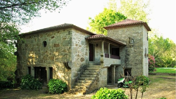 A stone building with a staircase leading to a porch, surrounded by greenery. - Quinta do Arquinho, River, Pool and Nature (Ponte de Lima)