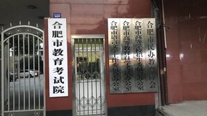 A building entrance with a signboard and a metal gate. - Vatica Hefei Lujiang Road Hotel (Hefei)