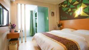 A hotel room with a bed, a bedside table with a vase of flowers, a wall-mounted air conditioner, and a geometric wall decoration. - Vatica Hefei Lujiang Road Hotel (Hefei)
