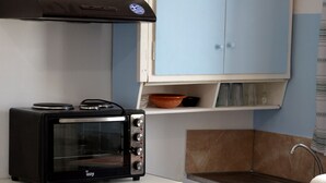 A compact kitchen with a toaster oven, a blue cabinet, and a sink. - Stunning 2-bed Apartment in Ios (Ios)