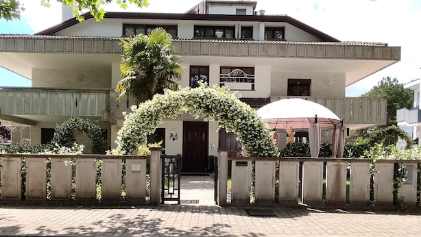 A two-story building with a flat roof, a balcony, and a covered porch. - splendid two-room apartment with pergola (Bibione)
