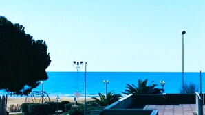 Eine Uferpromenade mit Blick auf das Meer, Straßenlaternen und einem Zaun.