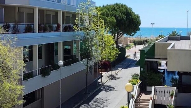 Ein modernes Hotel mit mehreren Balkonen mit Blick auf die Küste.