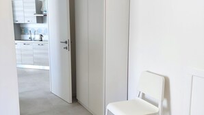 Ein Schlafzimmer mit einem Bett, einem weißen Stuhl und einem Kleiderschrank.