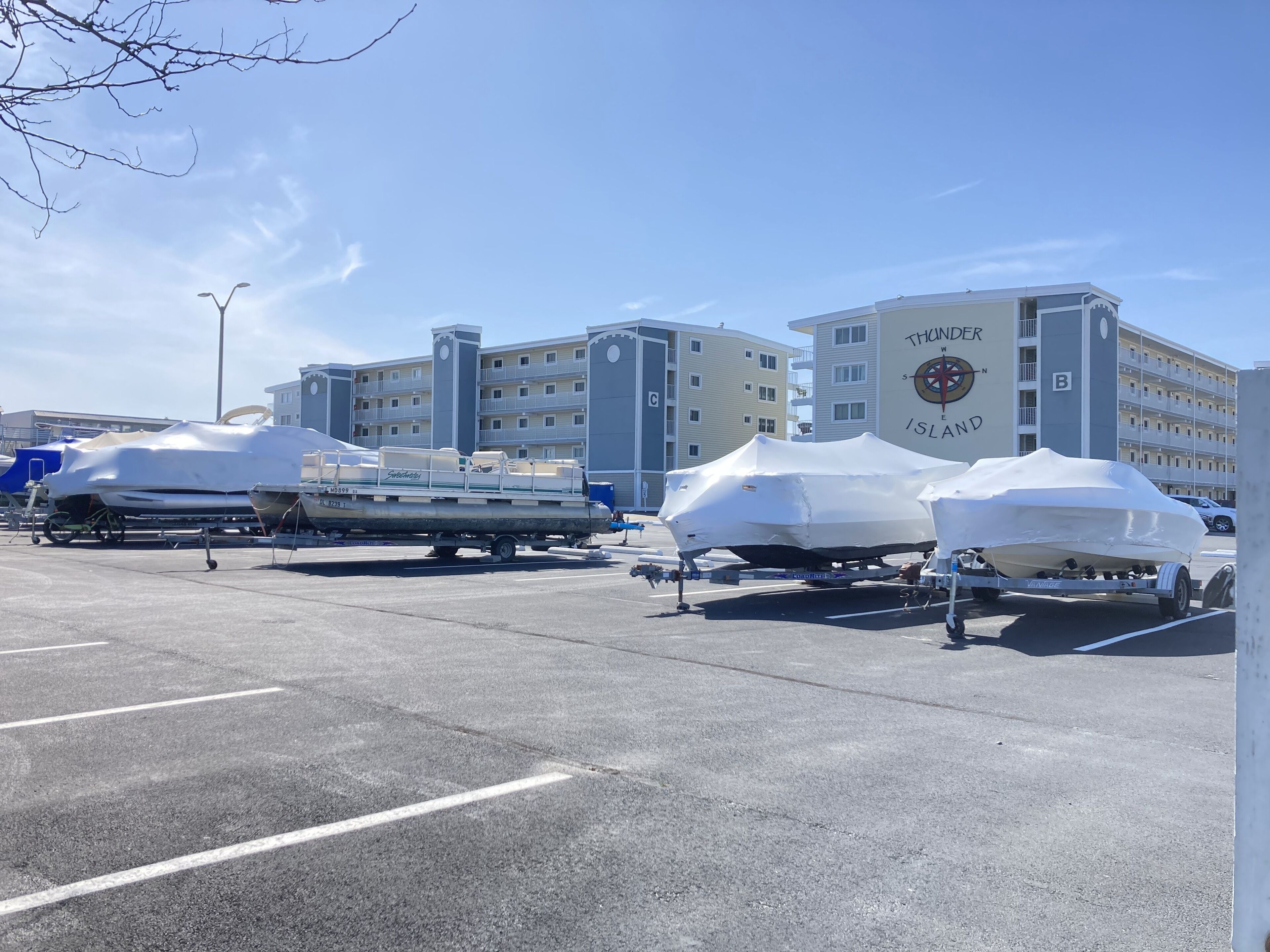 A parking lot with covered boats and a building labeled 'Thunder Island' in the background.