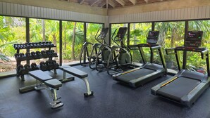 A gym with treadmills, elliptical machines, and dumbbells. - ALMOST HEAVEN ~ Stunning 2 Bedroom, 2 Bathroom Condo with Community Pool! (Key West)