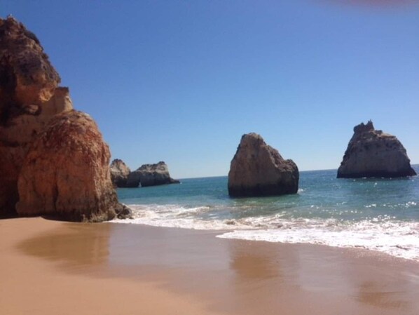 A beach with large rock formations and clear blue water. - Fantástica Casa com 4 Quartos na Prainha (Alvor)