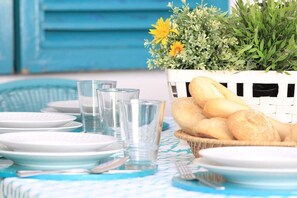 A table set with plates, glasses, and a basket of bread. - Fantástica Casa com 4 Quartos na Prainha (Alvor)