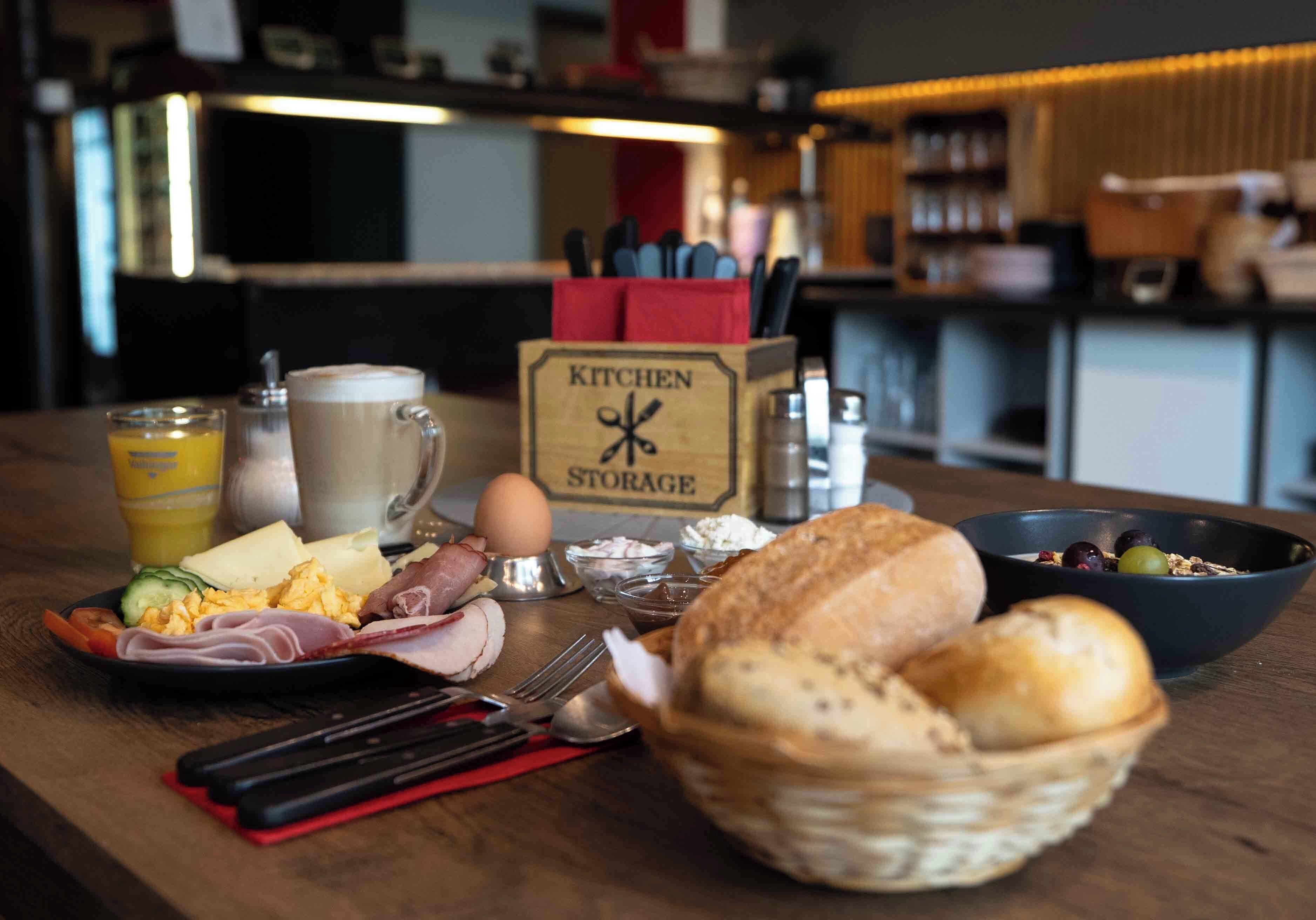 Een ontbijttafel met diverse etenswaren, zoals eieren, kaas en brood.