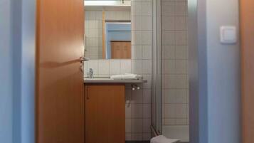 A bathroom with a wooden cabinet, a sink, and a mirror.