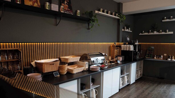 A modern kitchen with a wooden countertop, built-in appliances, and storage shelves.
