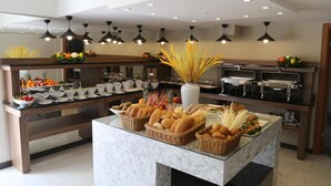 A buffet setup with various food items and a central vase. - Avwan Hotel Cigli (Izmir)
