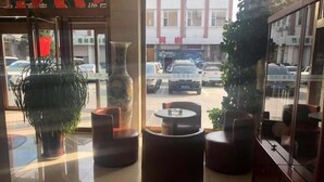 A lobby with a large vase, a potted plant, and a seating area with a round table and chairs. - Greentree Inn Xinzhou Jianshe Road Express Hotel (Xinzhou)