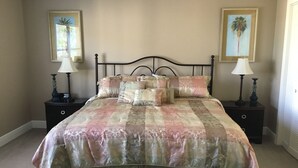 Un dormitorio con cama, dos mesitas de noche y dos lámparas.