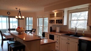 A kitchen with a central island, white cabinets, a dishwasher, and a window with a view. - Amazing! Tellico village lake house with dock! (Loudon)