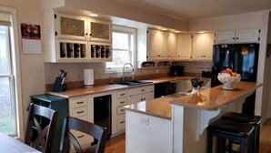 A kitchen with white cabinets, a black refrigerator, and a granite countertop. - Amazing! Tellico village lake house with dock! (Loudon)
