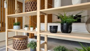 A wooden shelving unit with various potted plants and decorative items. - Phaedrus Living: Seaside Luxury Flat Athina 123 (Paphos)