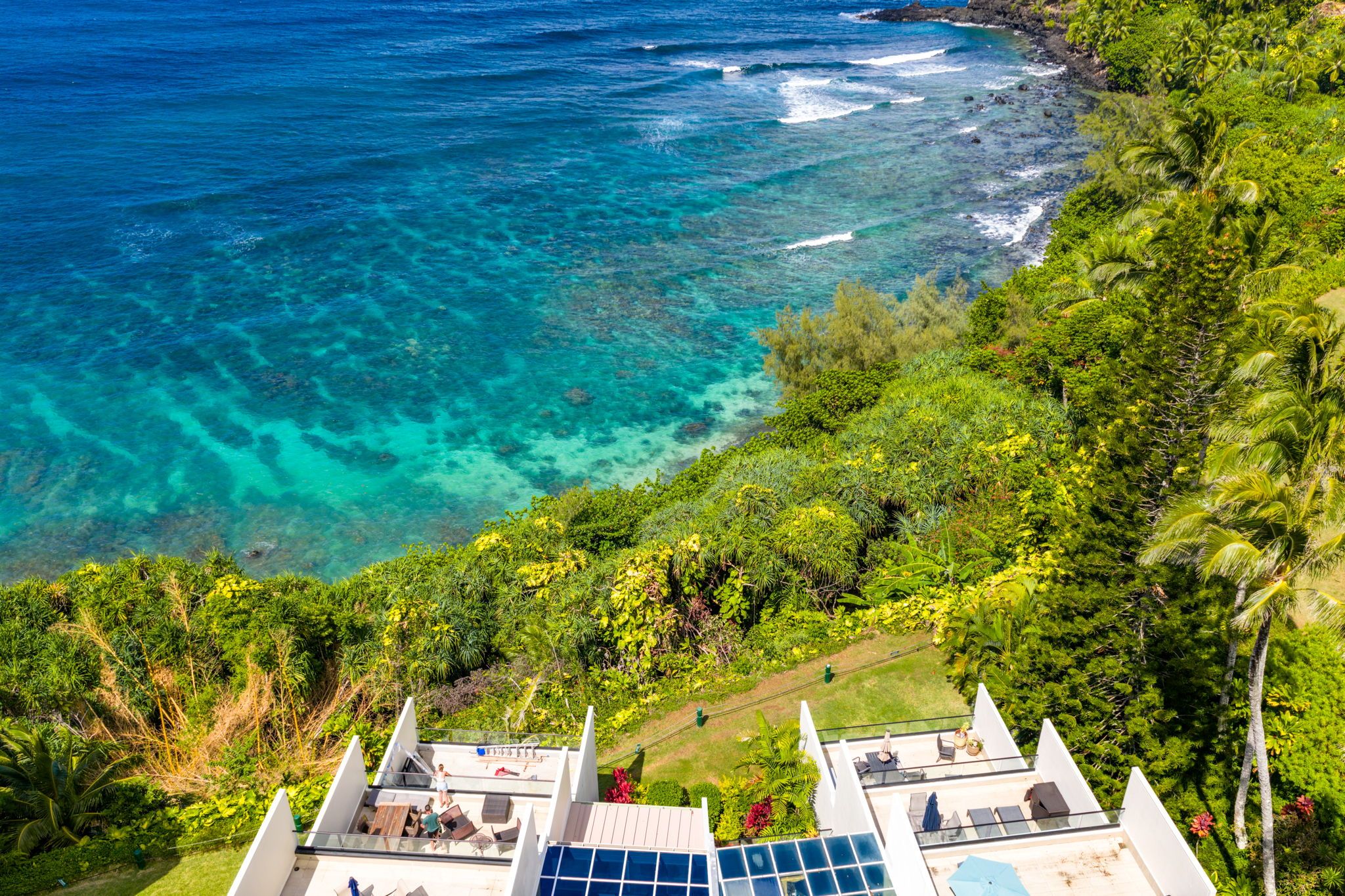 A resort with a view of the ocean and lush greenery.