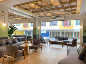 A spacious lounge area with multiple seating options, including sofas and chairs, arranged around a central coffee table. - Dewinda Lubuk Linggau (Lubuklinggau)