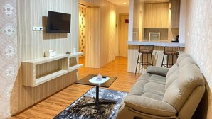 Una sala de estar moderna con un sofá, una mesa de centro y un televisor montado en la pared.