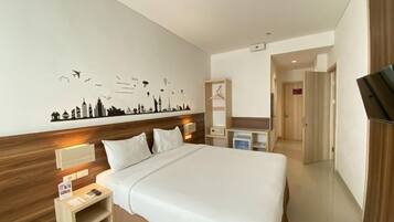 Habitación de hotel moderna con una cama grande, mesitas de noche, un televisor y un cuadro con un paisaje urbano.