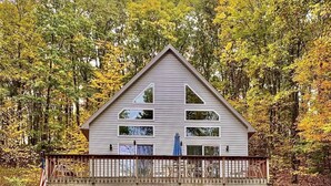Ein zweigeschossiges Haus mit Balkon, Garage und Veranda.