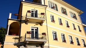 Un immeuble à plusieurs étages doté de balcons, de grandes fenêtres et de jardinières.
