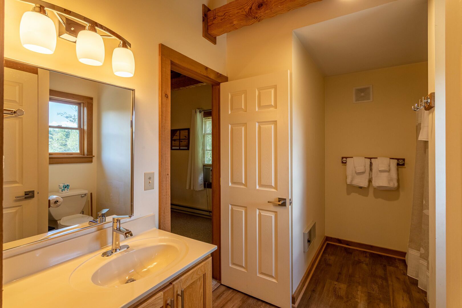 A bathroom with a sink, mirror, and towel rack.