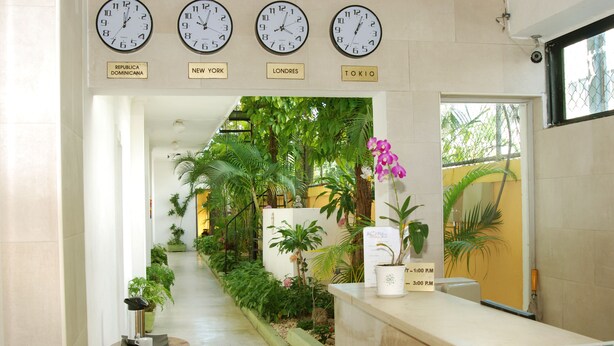 A reception area with clocks displaying times for Republica Dominicana, New York, Londres, and Tokio. - Quiet and comfortable room in the center. B&B (Santo Domingo)