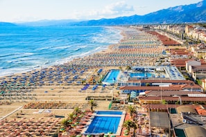 A coastal hotel with a large swimming pool, beach umbrellas, and a view of the sea. - La Suite 2 Ondina Viareggio 200m from sea (Viareggio)